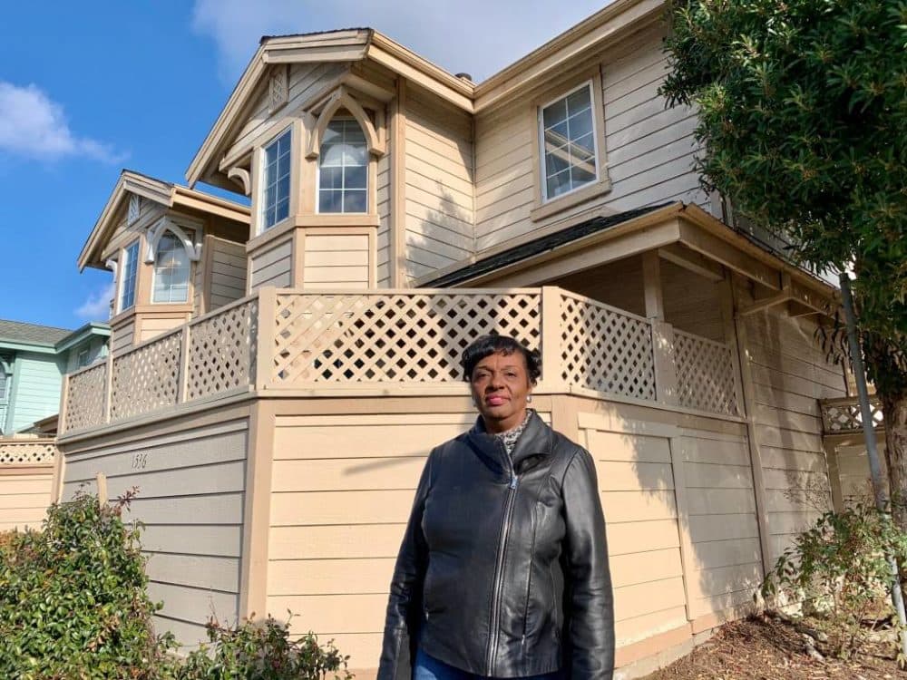Gayla Newsome stands in front of her Oakland home. (Molly Solomon/KQED)