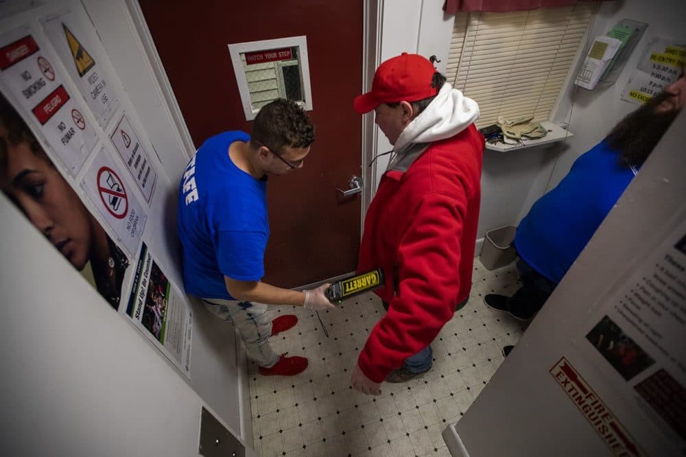 All guest's items are inspected and their bodies are checked using a metal detector before entering the shelter Our Father’s House in Fitchburg. (Jesse Costa/WBUR)