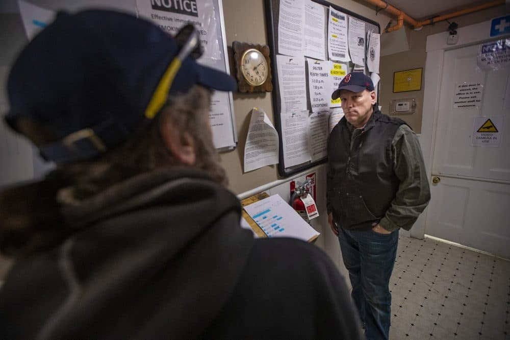 Director of Homeless Services Kevin MacLean speaks with a guest checking in to Our Father’s House. (Jesse Costa/WBUR