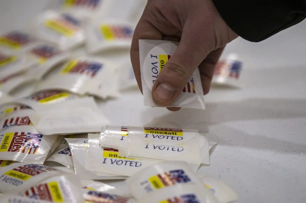 A voter picks up an “I Voted” sticker after going to the polls at Oyster River High School in Durham, N.H. (Jesse Costa/WBUR)