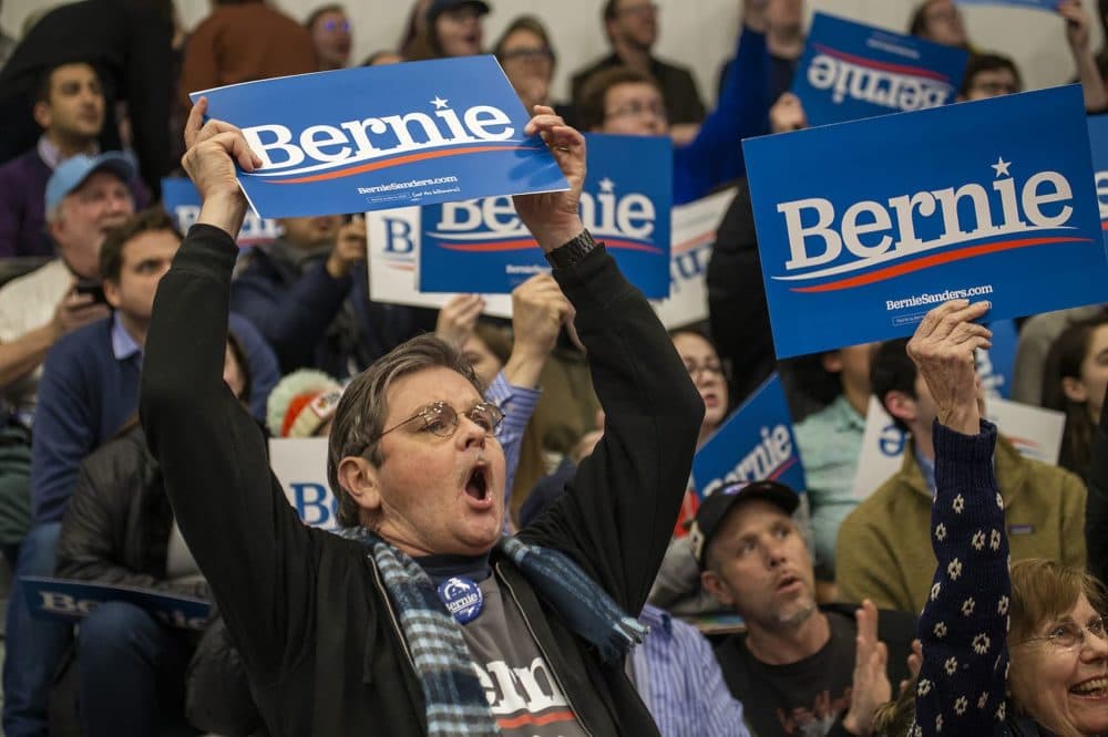 Bernie Sanders supporter William Collins of Harwich, Mass. waves a Bernie sign at the senator&#039;s primary night rally. (Jesse Costa/WBUR)