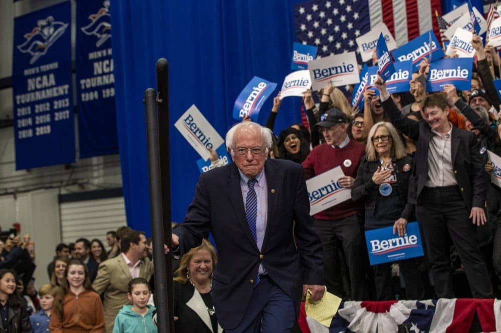 Presidential candidate Bernie Sanders climbs the steps to the podium to greet supporters after his primary victory in the New Hampshire Primary. (Jesse Costa/WBUR)