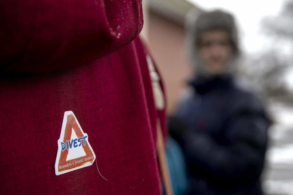 A protester wears a &quot;Divest&quot; sticker during a Brandeis Climate Justice demonstration. (Robin Lubbock/WBUR)