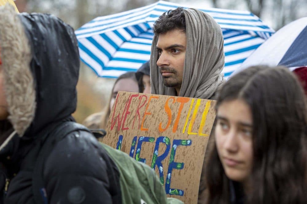 Ph.D student Aneil Tripathy holds up a banner at a Brandeis Climate Justice demonstration. (Robin Lubbock)