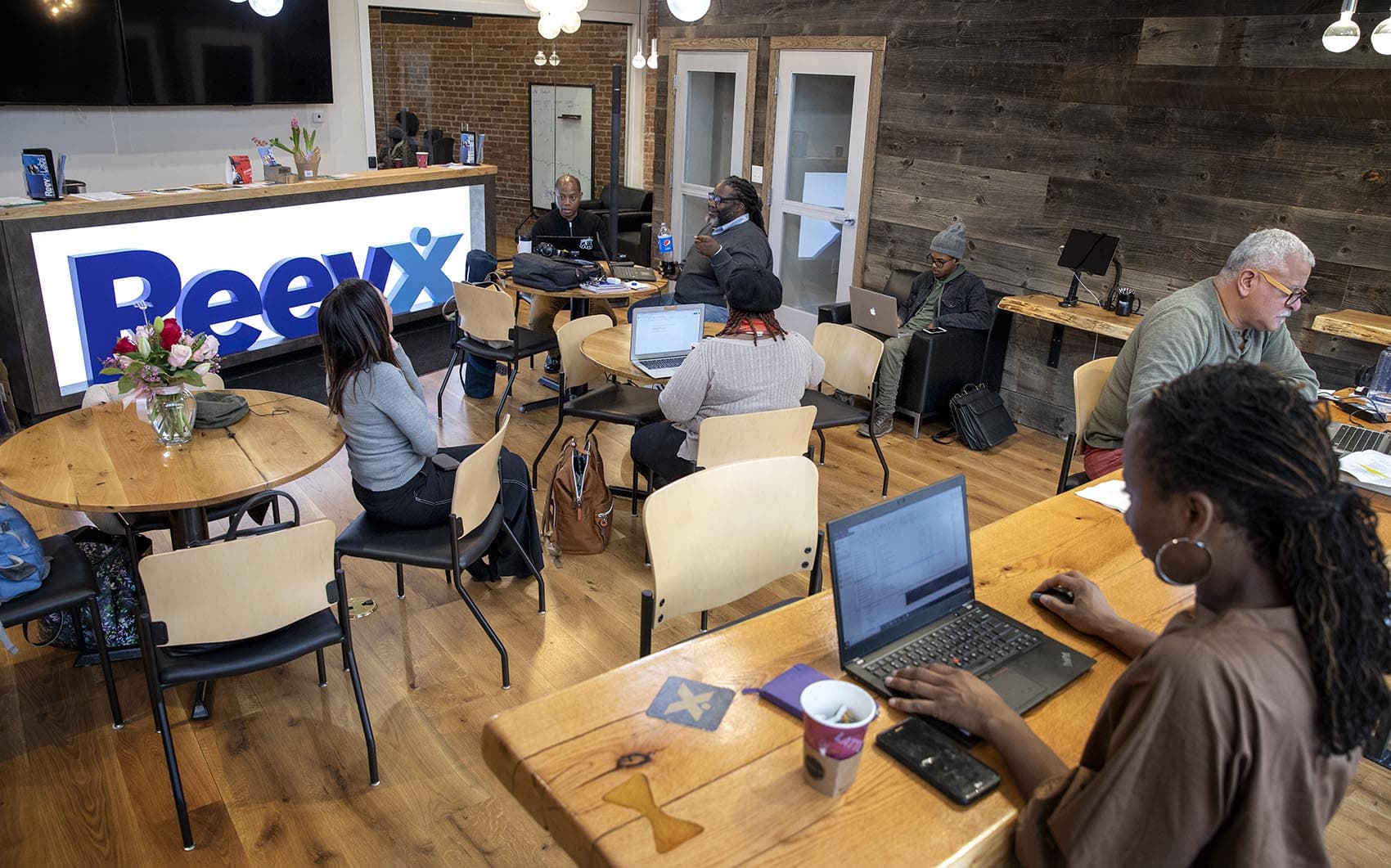 People work on their laptops in the main work space at Reevx Labs on Washington Street in Roxbury. (Robin Lubbock/WBUR)