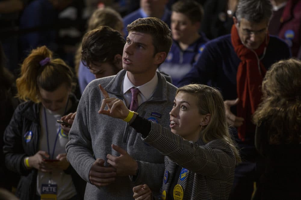 Kyle McLellan, 20, and Ashley Guzik, 21, both of San Diego, California,  are volunteers for former South Bend, Indiana, Mayor Pete Buttigieg and watched the early returns roll in for the New Hampshire primary. (Joe Difazio for WBUR)