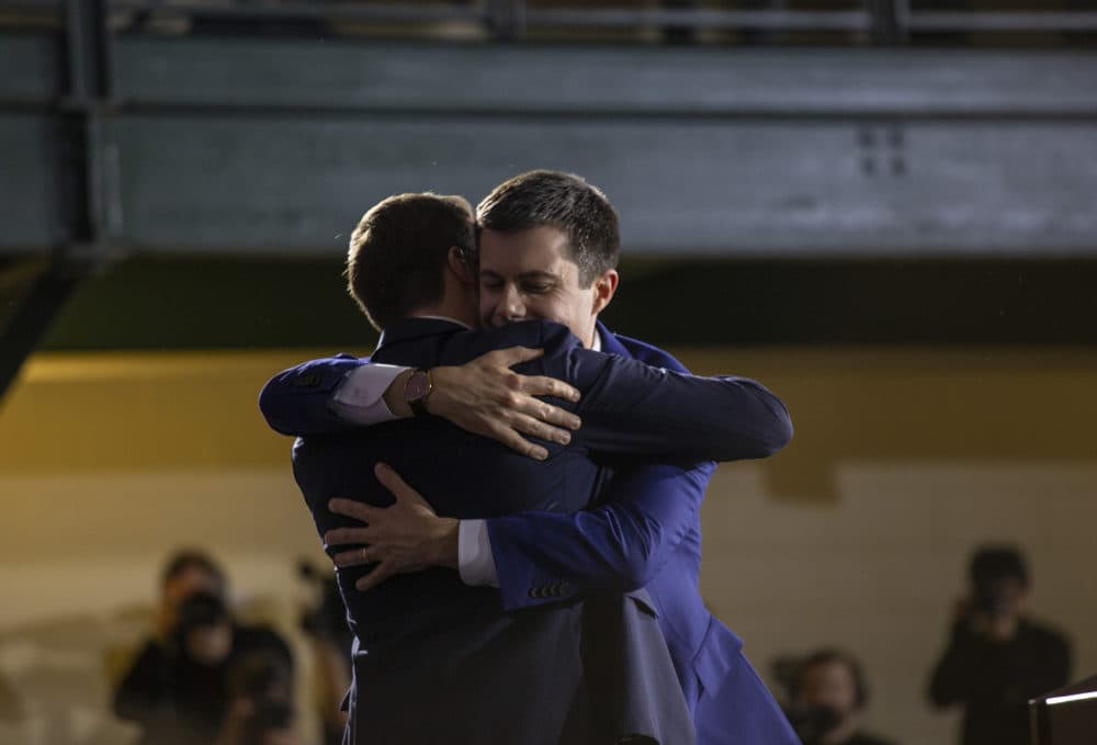 Former South Bend, Indiana, Mayor Pete Buttigieg embraces his husband Chasten at his primary night rally in Nashua. (Joe Difazio for WBUR)