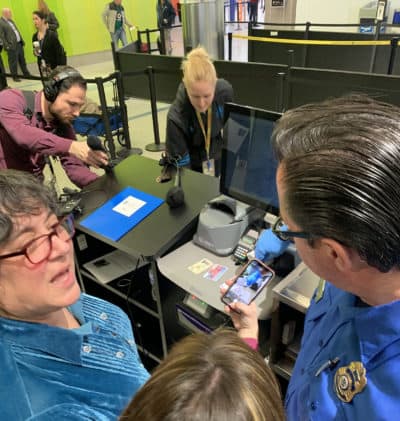 TSA spokeswomanLisa Farbstein, left, and TSA officer James Freel demonstrate Logan Airport's new credential authentication machines. (Simón Rios/WBUR)