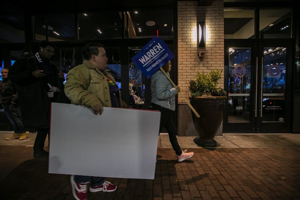 Warren supporters with signs arrive at Tony C’s for the campaign party where about 50 people attended. The event was closed to press. (Jesse Costa/WBUR)