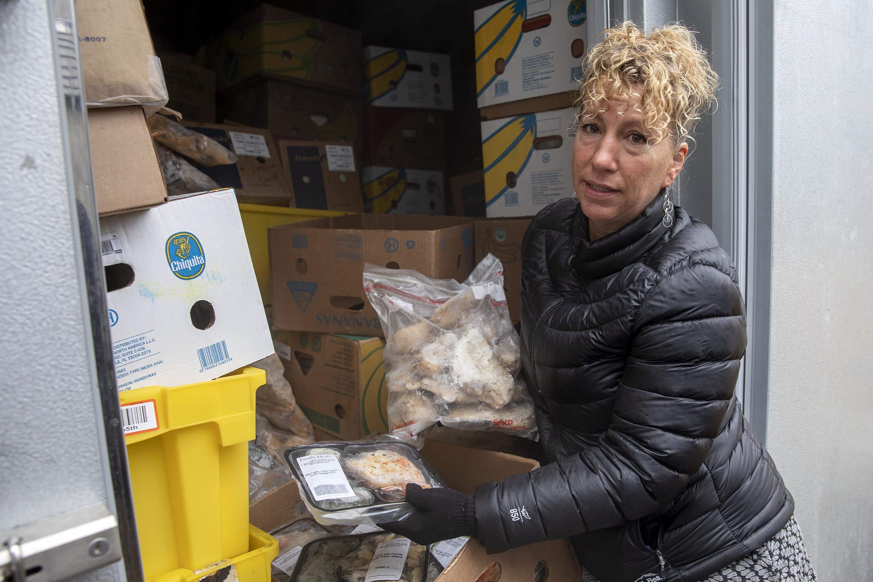 Sasha Purpura, executive director of Food For Free, Cambridge looks through food packages in an organization freezer. (Robin Lubbock/WBUR)