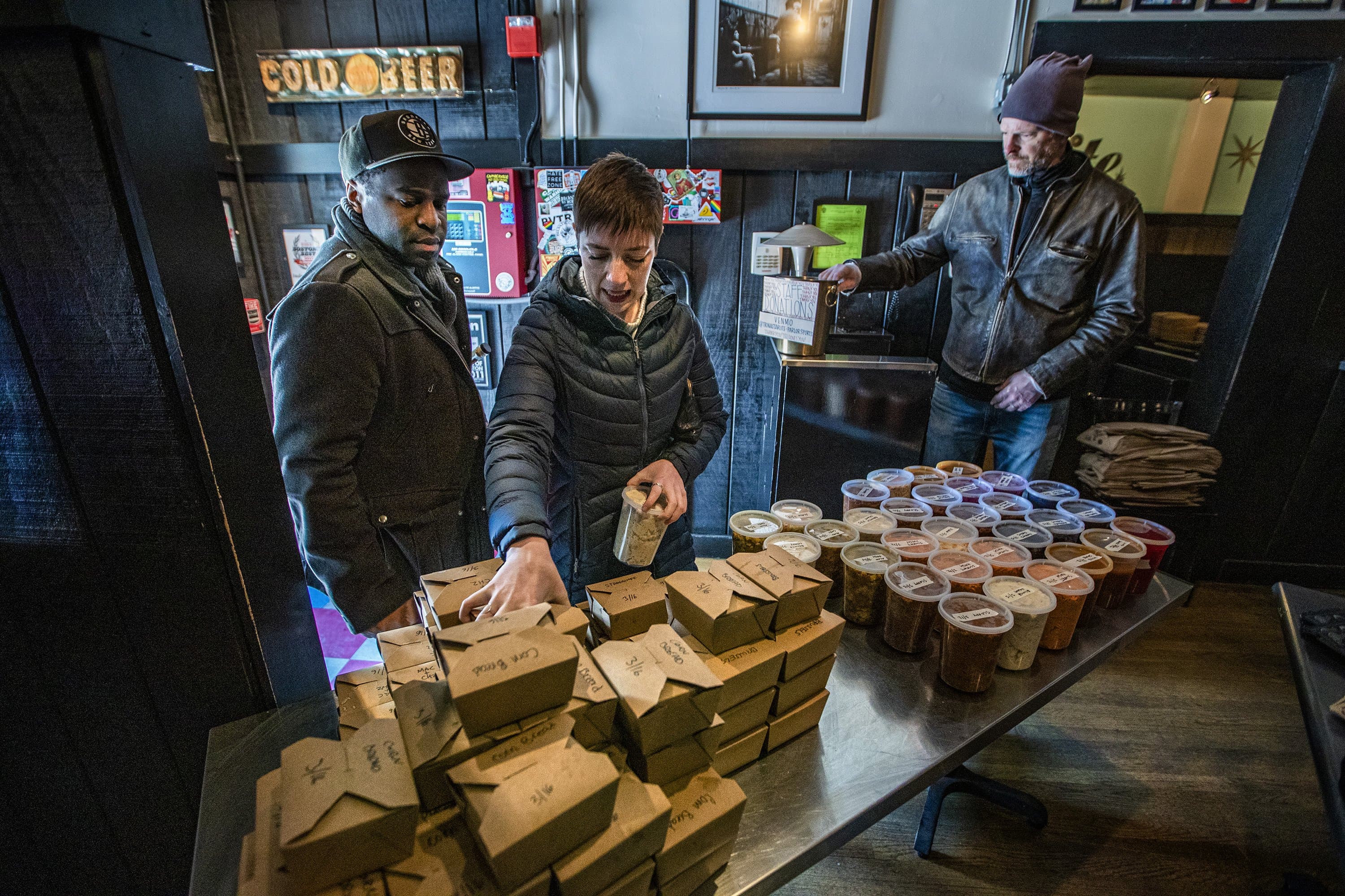 Patrons at Trina’s Starlite Lounge in Somerville pick out meals for take out. All the proceeds of the sales will go to their staff. (Jesse Costa/WBUR)