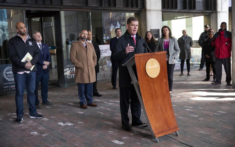Boston Mayor Marty Walsh, flanked by city councilors and staff, at a press conference in front of City Hall. (Robin Lubbock/WBUR)