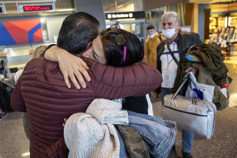 Alaa Issa hugs his sister Lina, as she and her family arrive at Logan Airport. (Robin Lubbock/WBUR)
