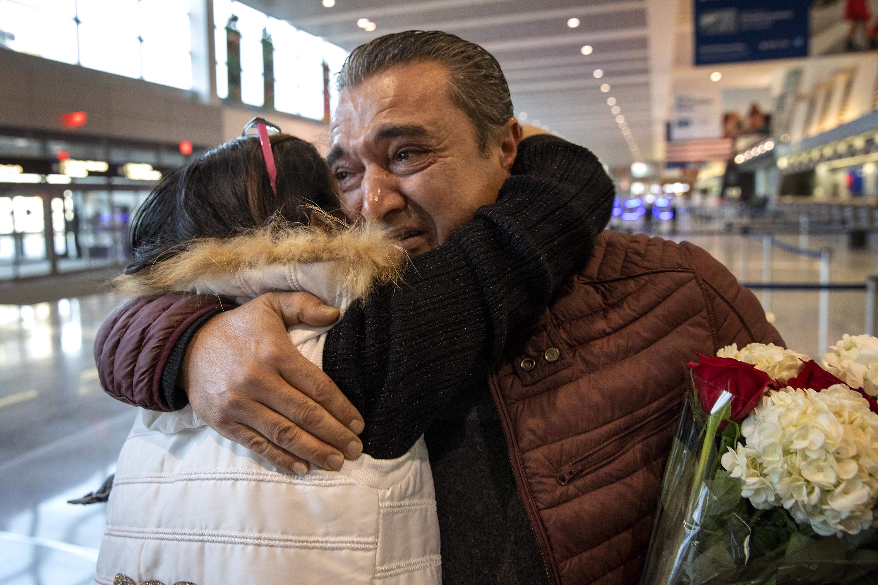 Alaa Issa hugs his sister Lina, as she and her family arrive at Logan Airport. (Robin Lubbock/WBUR)