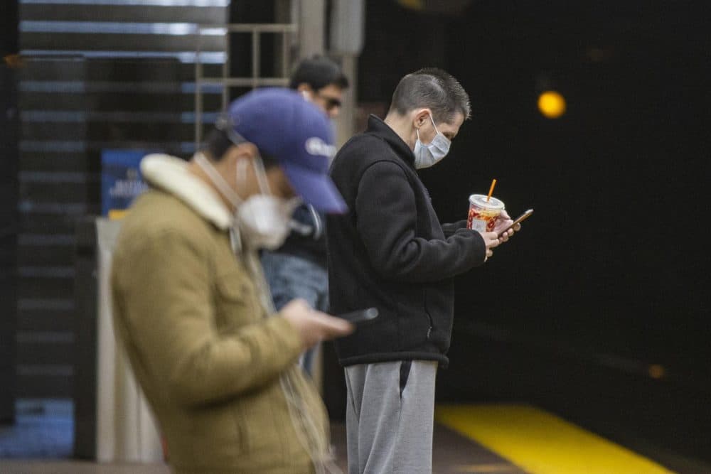 Two passengers wearing masks waiting for a Green Line train at the MBTA station at Park Street. (Jesse Costa/WBUR)