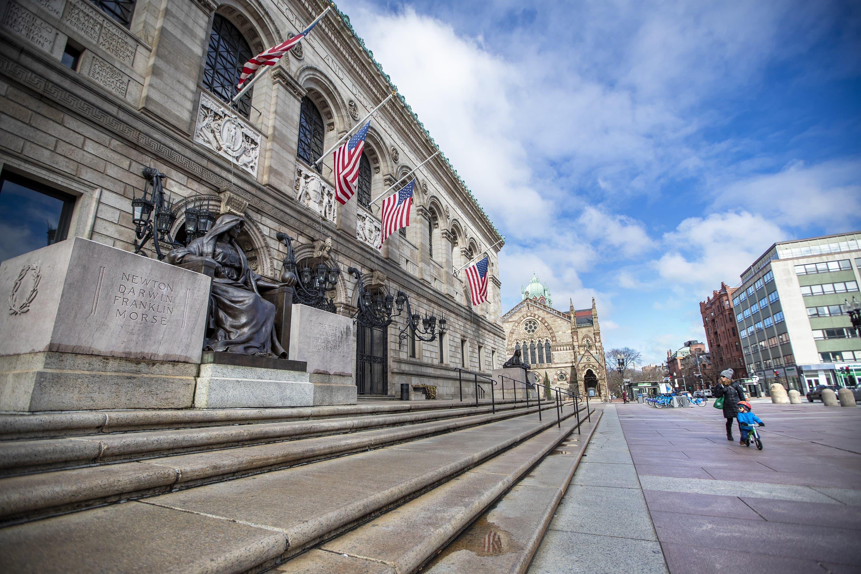 A mother and her son look at the closed Boston Public Library last month. (Jesse Costa/WBUR)
