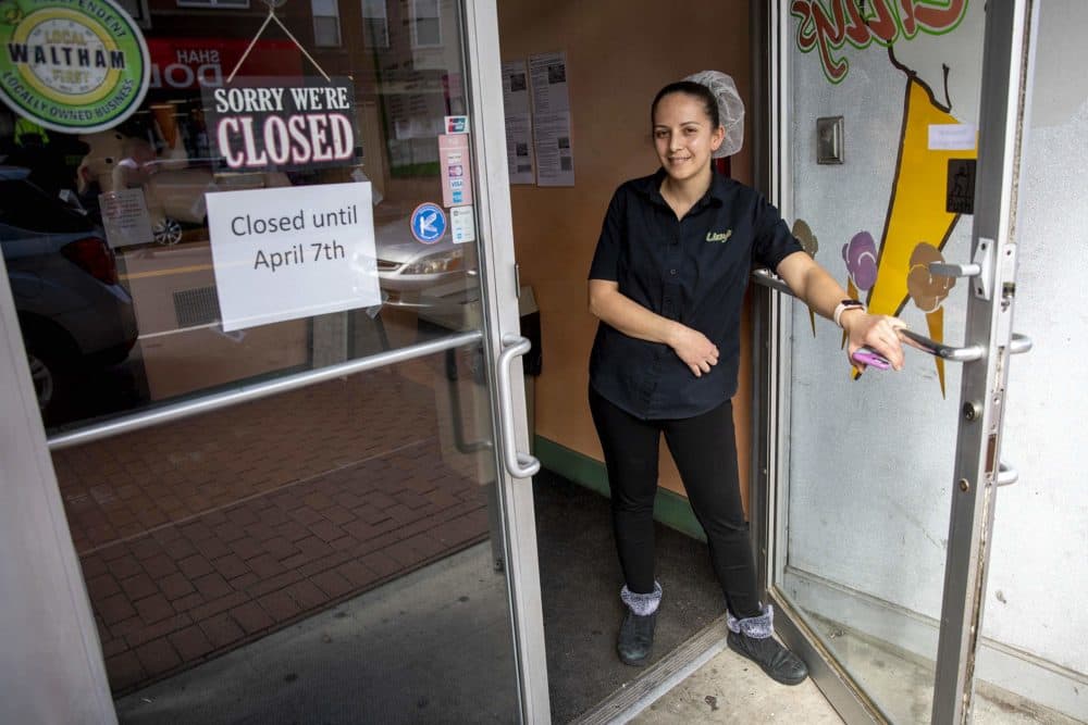Miriam Benitez, owner of Lizzy's ice cream, holds the door open as she talks to a visitor. (Robin Lubbock/WBUR)