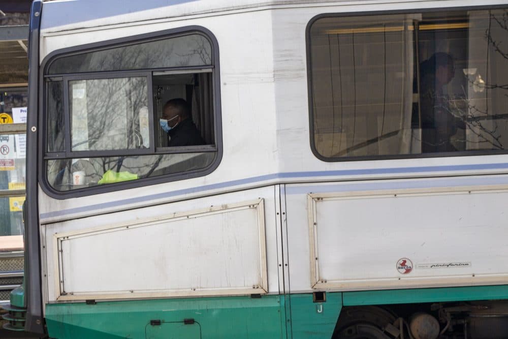 An MBTA Green Line train driver wearing a mask makes a stop at the Longwood Stop on Huntington Ave. (Jesse Costa/WBUR)