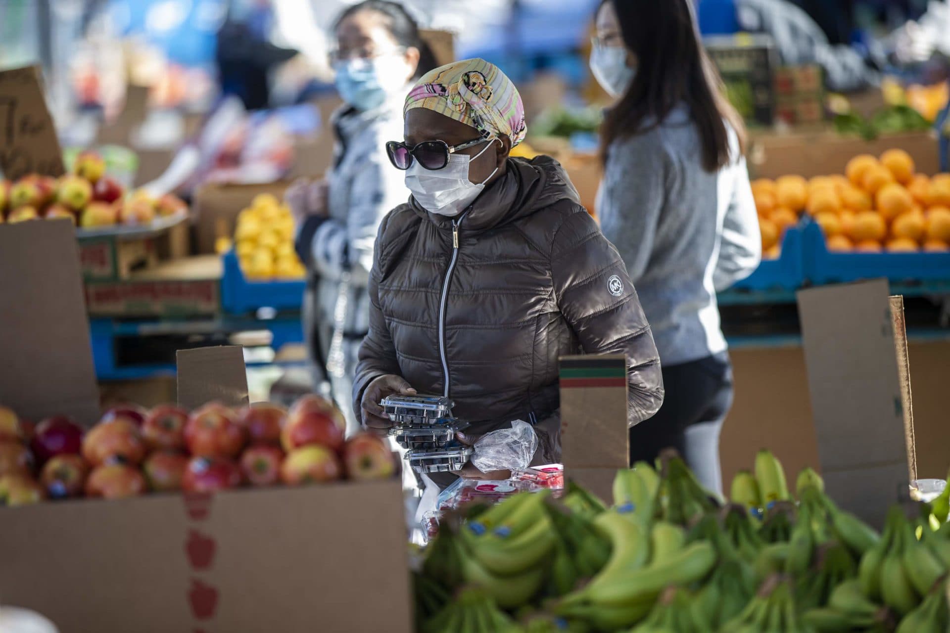March 27: A woman peruses the fruit at one of the stands at Haymarket on Blackstone Street. (Jesse Costa/WBUR)