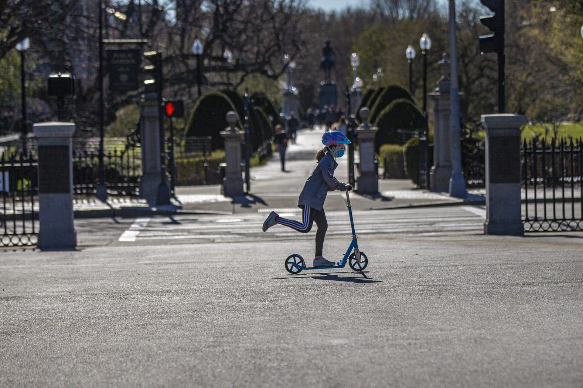 March 27: A young girl rides her scooter in Boston Common along Charles Street. (Jesse Costa/WBUR)