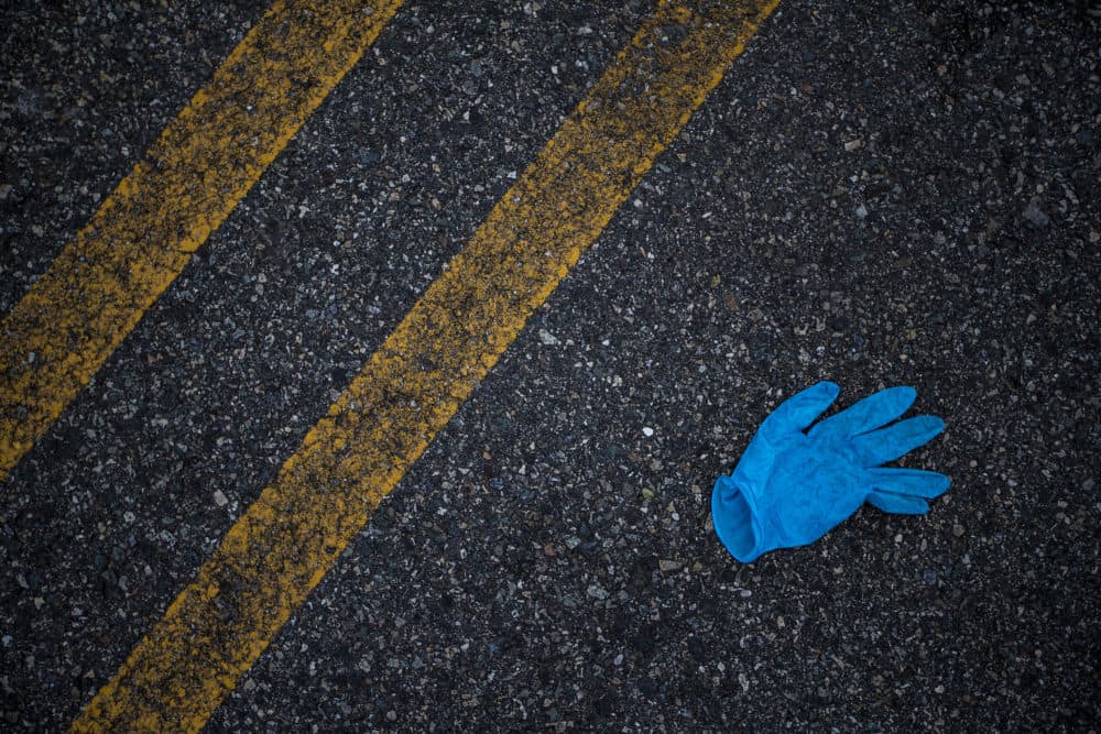 A Discarded nitrile glove in a parking lot in Medford. (Jesse Costa/WBUR)