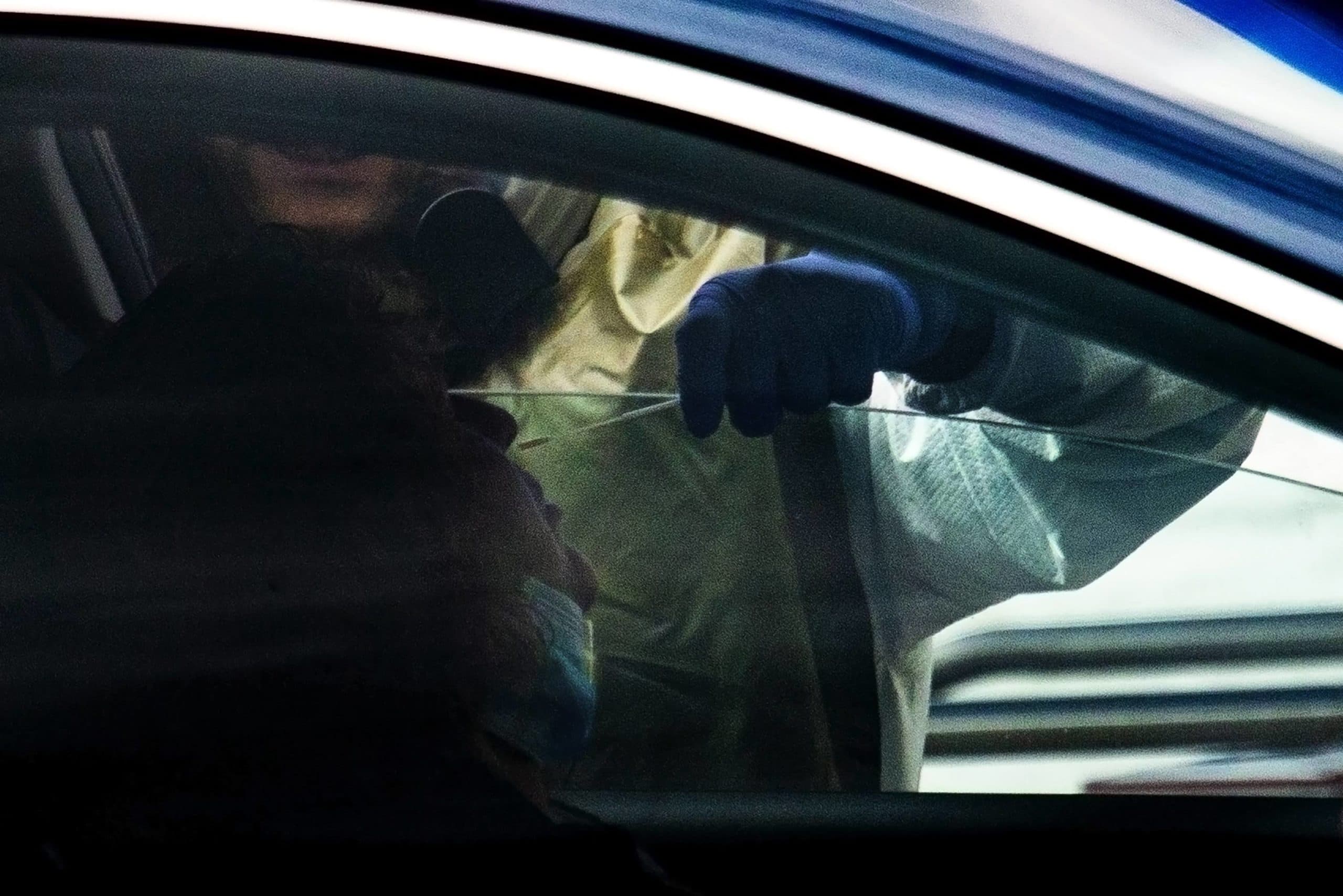 A healthcare worker performs a nasopharyngeal specimen collection at the drive-thru COVID-19 testing site at Somerville Hospital. (Jesse Costa/WBUR)