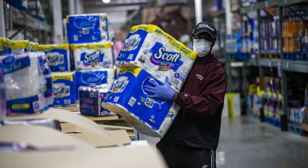 Instacart shopper Shamar Martin picks out paper products for customers at BJ’s Wholesale Club (Jesse Costa/WBUR)