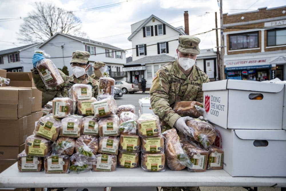 U.S. Army National Guard place loaves of bread for residents of Chelsea to pick up during a pop-up food pantry at Washington Park. (Jesse Costa/WBUR)