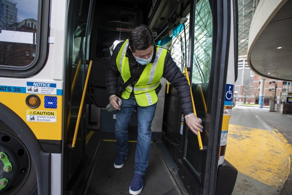 Diego Zabata finishes up disinfecting an MBTA bus at Haymarket Station after it finished its route from Woodlawn in Everett. (Jesse Costa/WBUR)