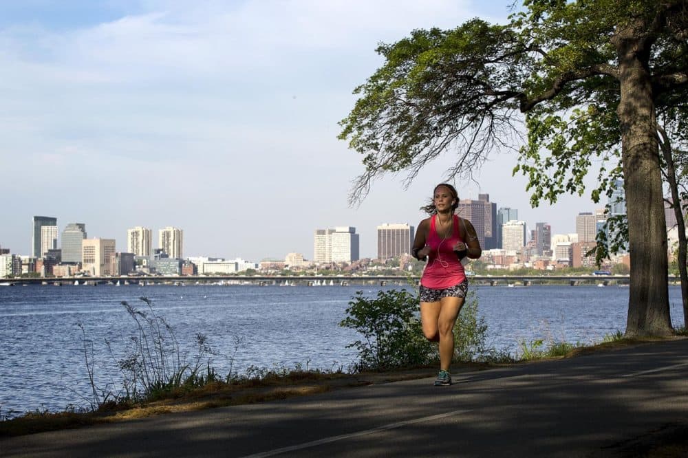 A woman runs along the Charles River in Boston. (Robin Lubbock/WBUR)