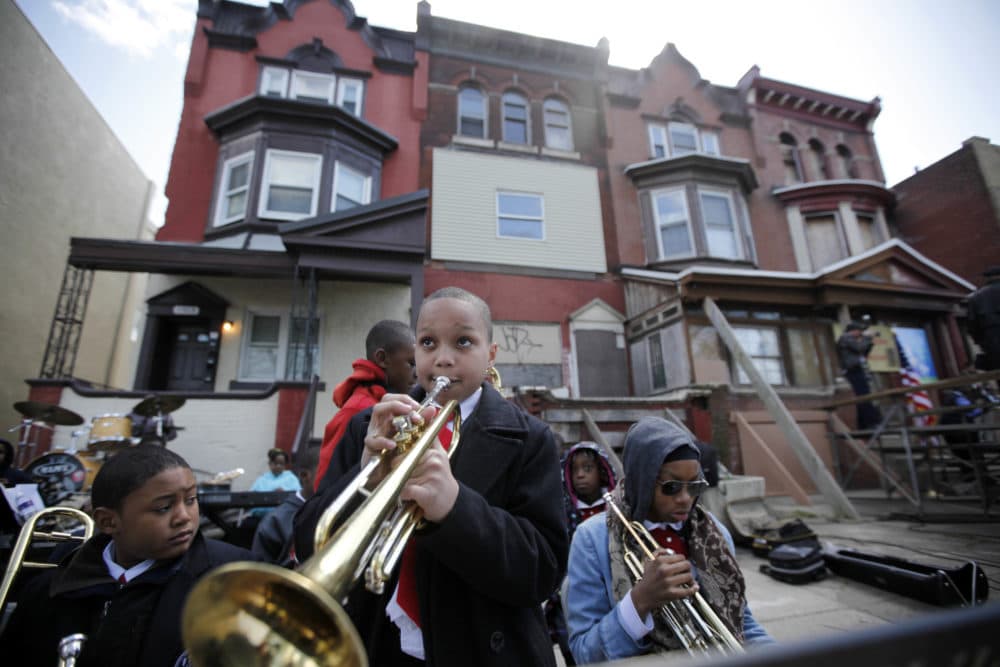 Students play music near the former home, third from left, of jazz musician John Coltrane in Philadelphia. Coltrane lived in a rowhouse in the city's Strawberry Mansion neighborhood from 1952 to 1958. (Matt Rourke/AP)