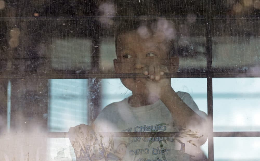 An immigrant child looks out from a U.S. Border Patrol bus leaving as protesters block the street outside the U.S. Border Patrol Central Processing Center Saturday, June 23, 2018, in McAllen, Texas. (David J. Phillip/AP)