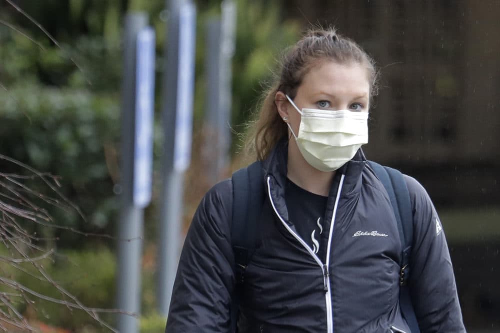 A woman wearing a mask walks away from the Life Care Center in Kirkland, Wash., near Seattle, on March 2. Health officials in Washington state said Sunday night that a second person had died from the coronavirus. (Ted S. Warren/AP)