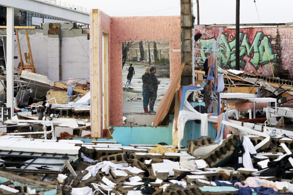 People are reflected in a mirror of a building destroyed by storms Tuesday, March 3, 2020, in Nashville, Tenn. Tornadoes ripped across Tennessee early Tuesday, shredding buildings and killing multiple people. (Mark Humphrey/AP)