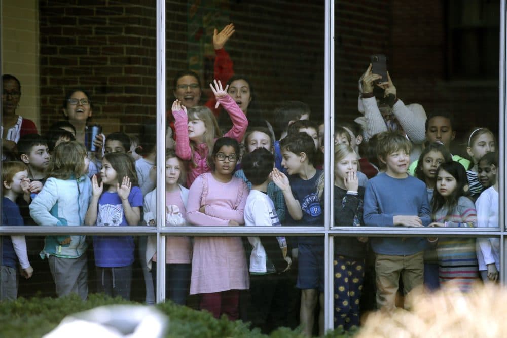 Students and teachers at the Graham and Parks Alternative Public School watch Elizabeth Warren walk past on her way to vote in Cambridge. (Steven Senne/AP)