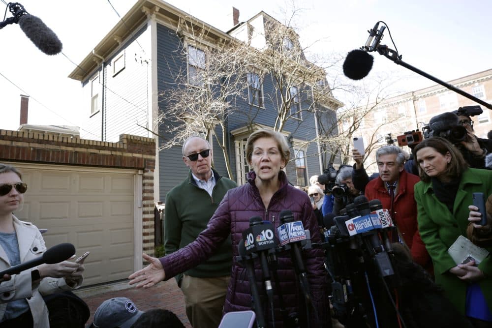 Sen. Elizabeth Warren, with her husband Bruce Mann beside her, speaks to the media outside her home Thursday in Cambridge, Mass., after she dropped out of the Democratic presidential race. (Steven Senne/AP)