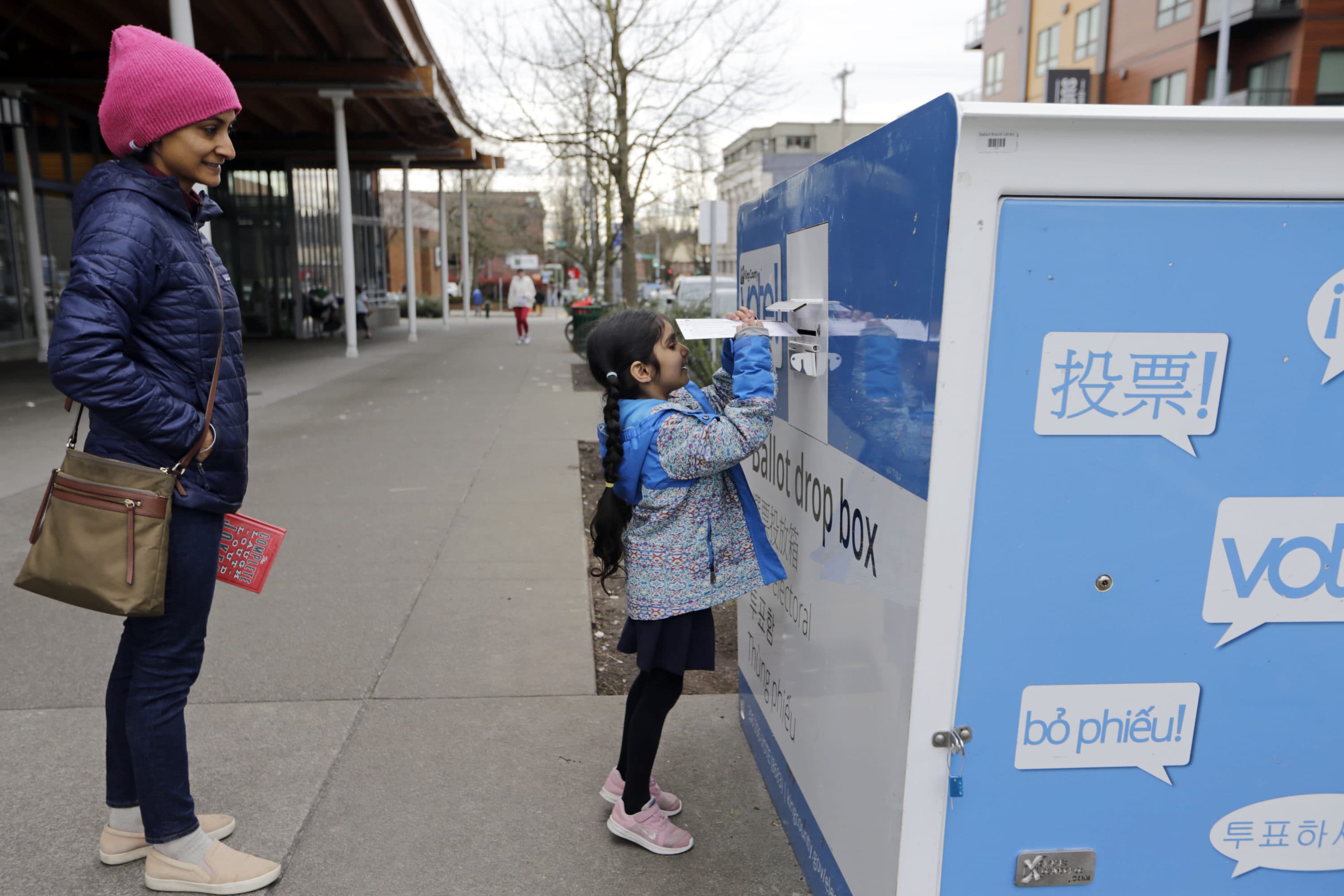 Gagan Thind watches as her daughter Seva drops off ballots in the Washington State primary, Tuesday, March 10, 2020 in Seattle. Washington is a vote by mail state. (John Froschauer/AP)