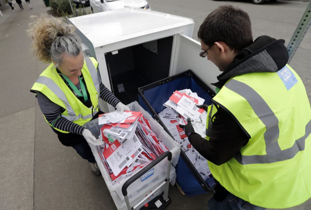 King County Election workers collect ballots from a drop box in the Washington State primary, Tuesday, March 10, 2020 in Seattle. Washington is a vote by mail state. (John Froschauer/AP)