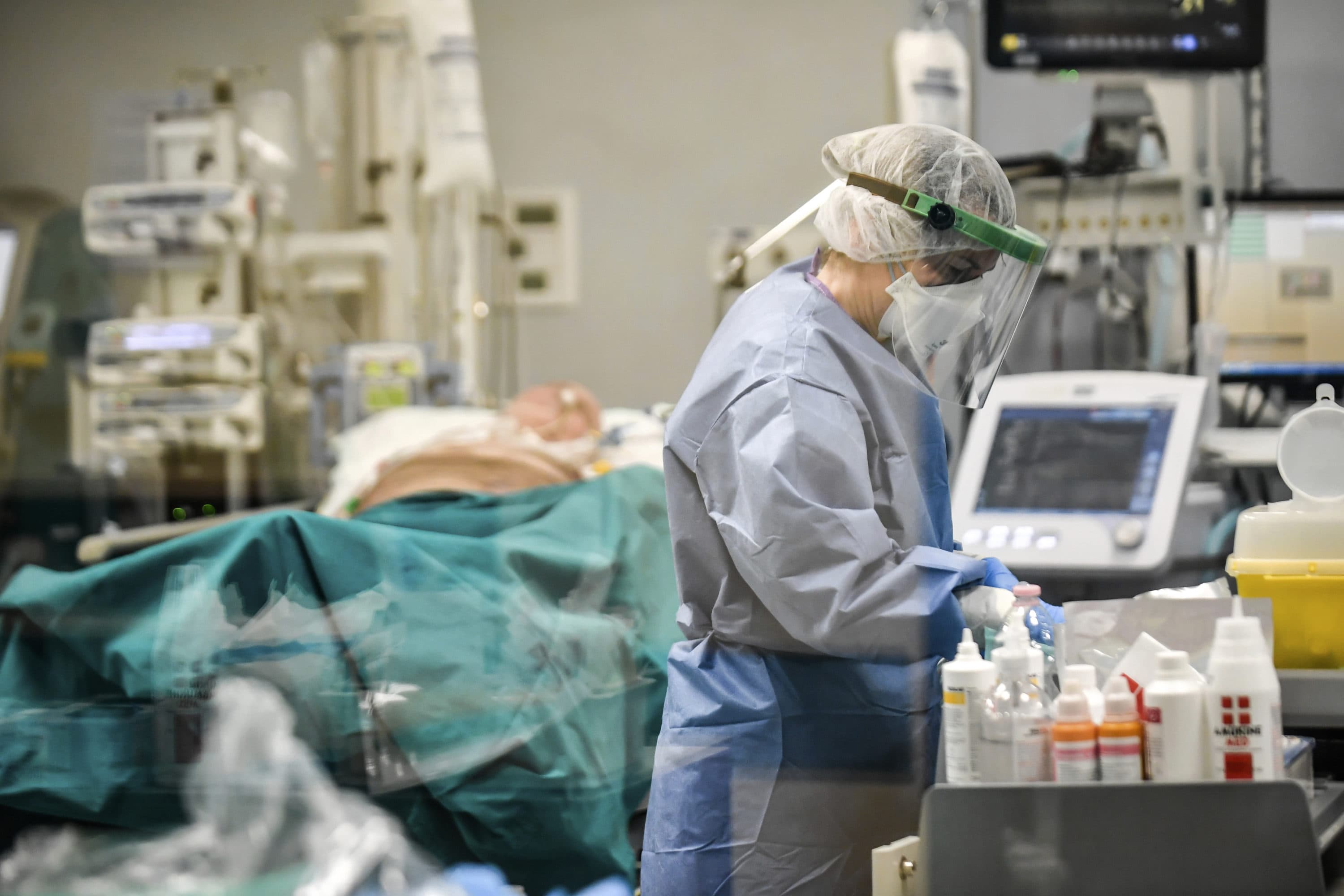 In this photograph taken from behind a window, doctors work on COVID-19 patients in the intensive care unit of San Matteo Hospital, in Pavia, northern Italy, Thursday, March 26, 2020. (Claudio Furlan/LaPresse via AP)