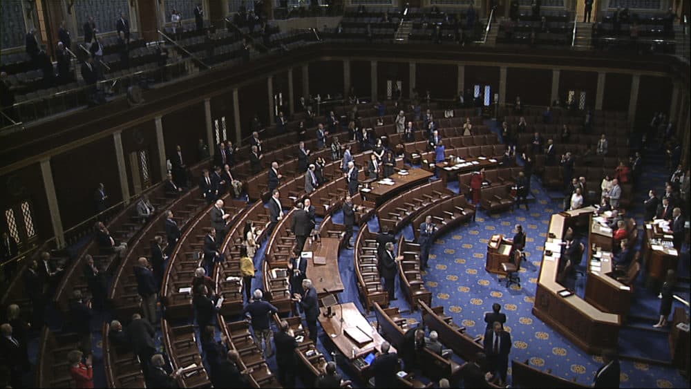 In this image from video, members of the House stand after they passed the coronavirus stimulus package on the floor of the House of Representatives at the U.S. Capitol in Washington, Friday, March 27, 2020. (House Television via AP)