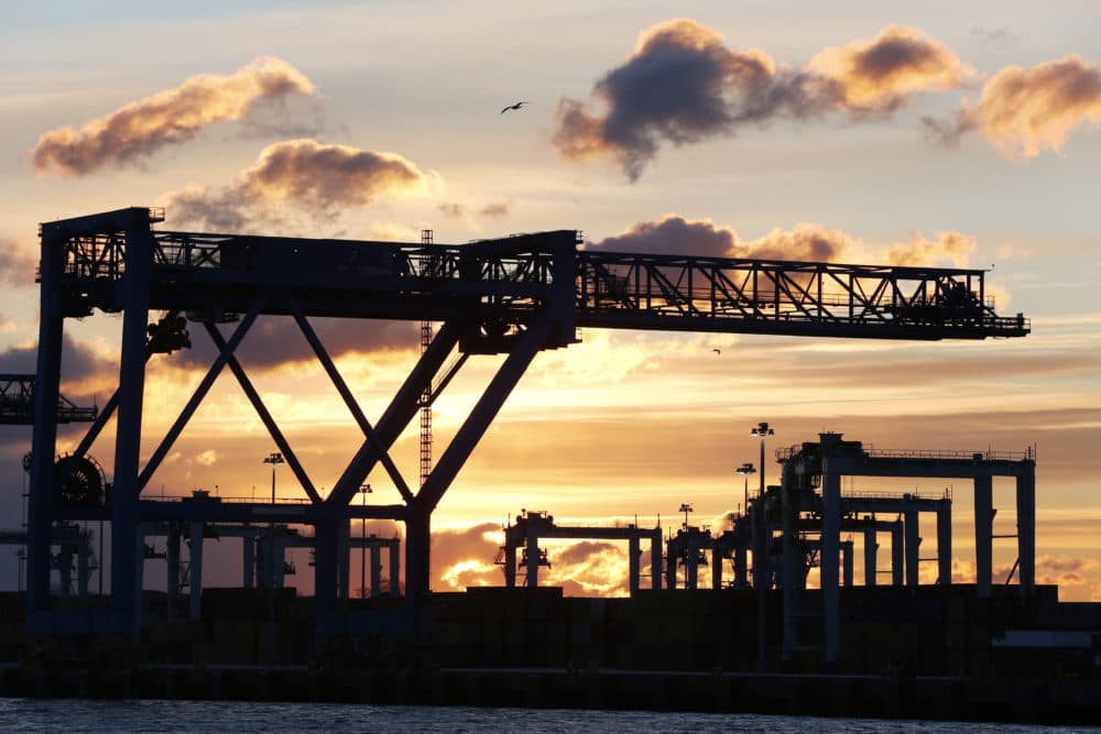 The sun rises behind cranes at the Port of Boston’s Conley Terminal in 2013. (Michael Dwyer/AP)