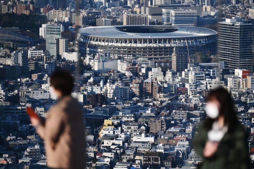 People look out from a highrise viewing area at the newly-built Japan National Stadium, the main venue for the 2020 Olympic Games, (Charly Triballeau/AFP via Getty Images)