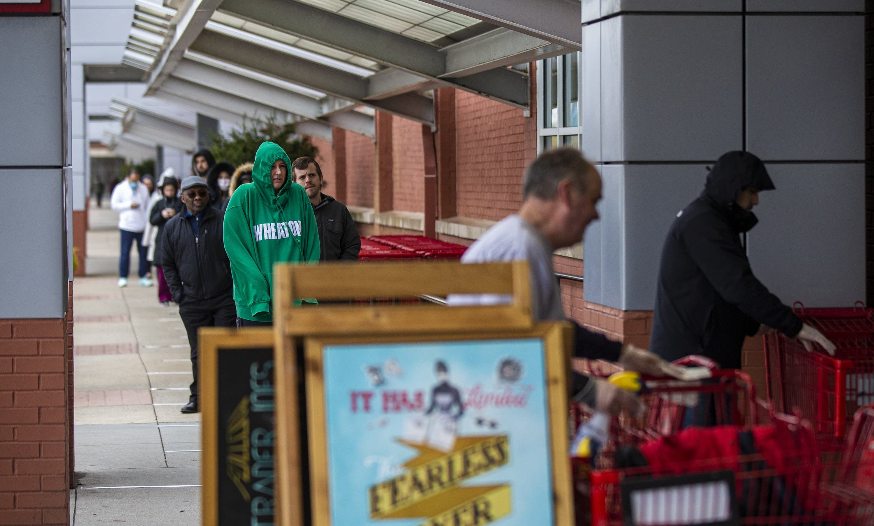 A long line of people wait to gain entrance into Trader Joe’s in Assembly Square. (Jesse Costa/WBUR)