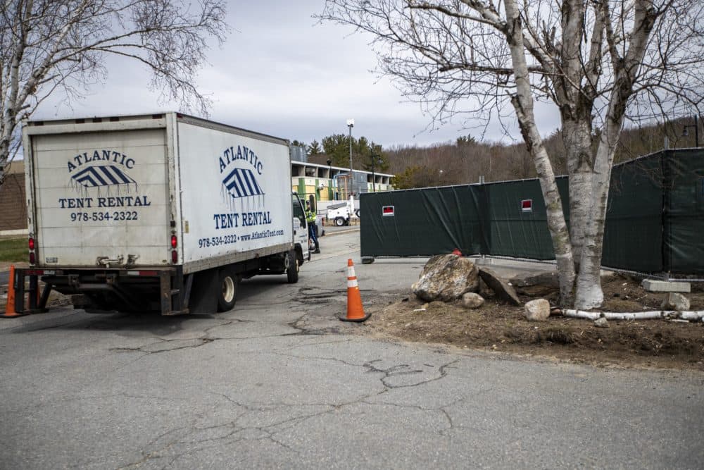 A tent rental truck arrives while construction of a temporary morgue is underway at Fitchburg State University’s Landry Arena. (Jesse Costa/WBUR)
