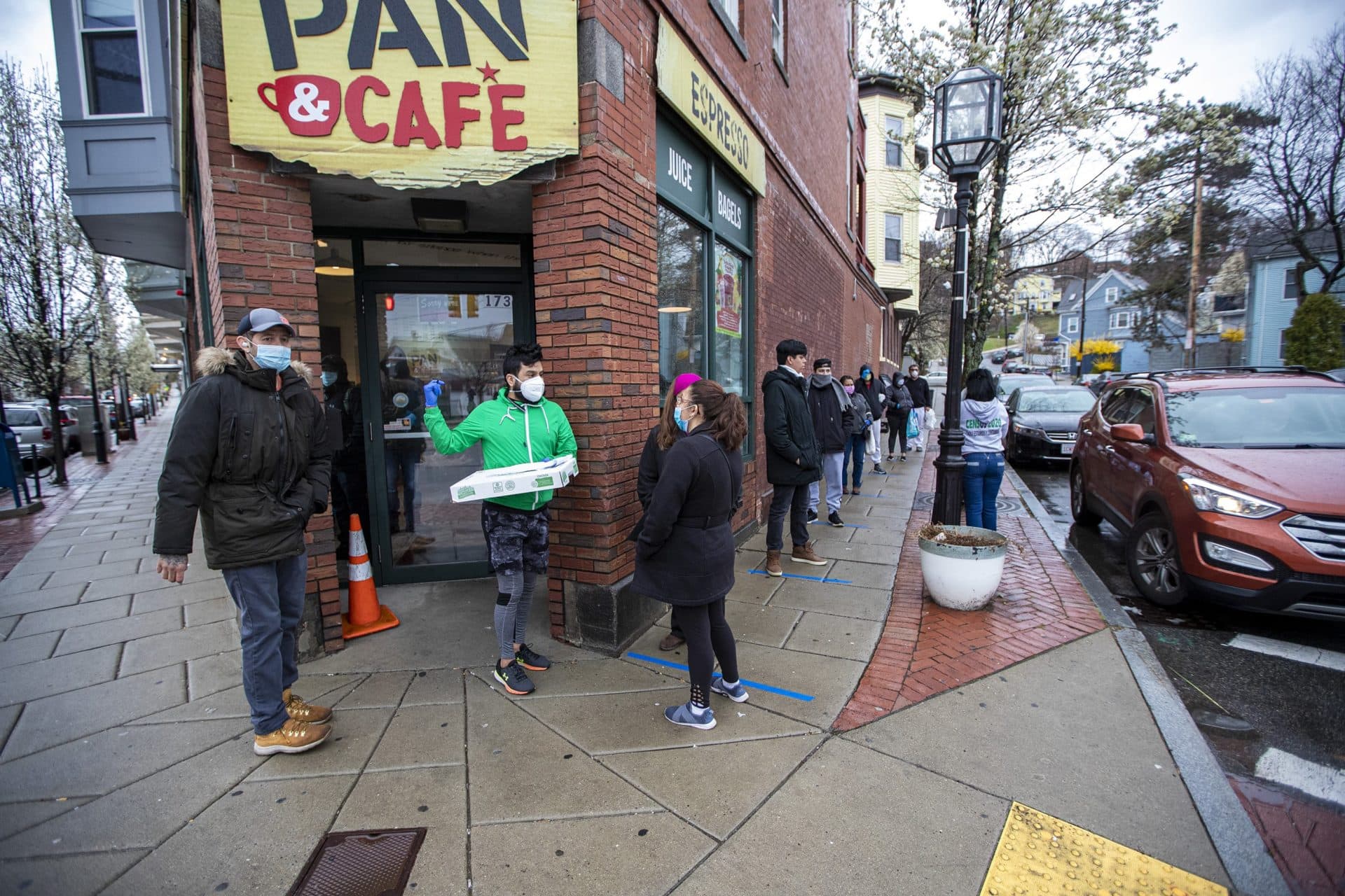 A line of Chelsea residents extends down Forsyth Street to place orders for food being distributed by the Chelsea Collaborative. (Jesse Costa/WBUR)