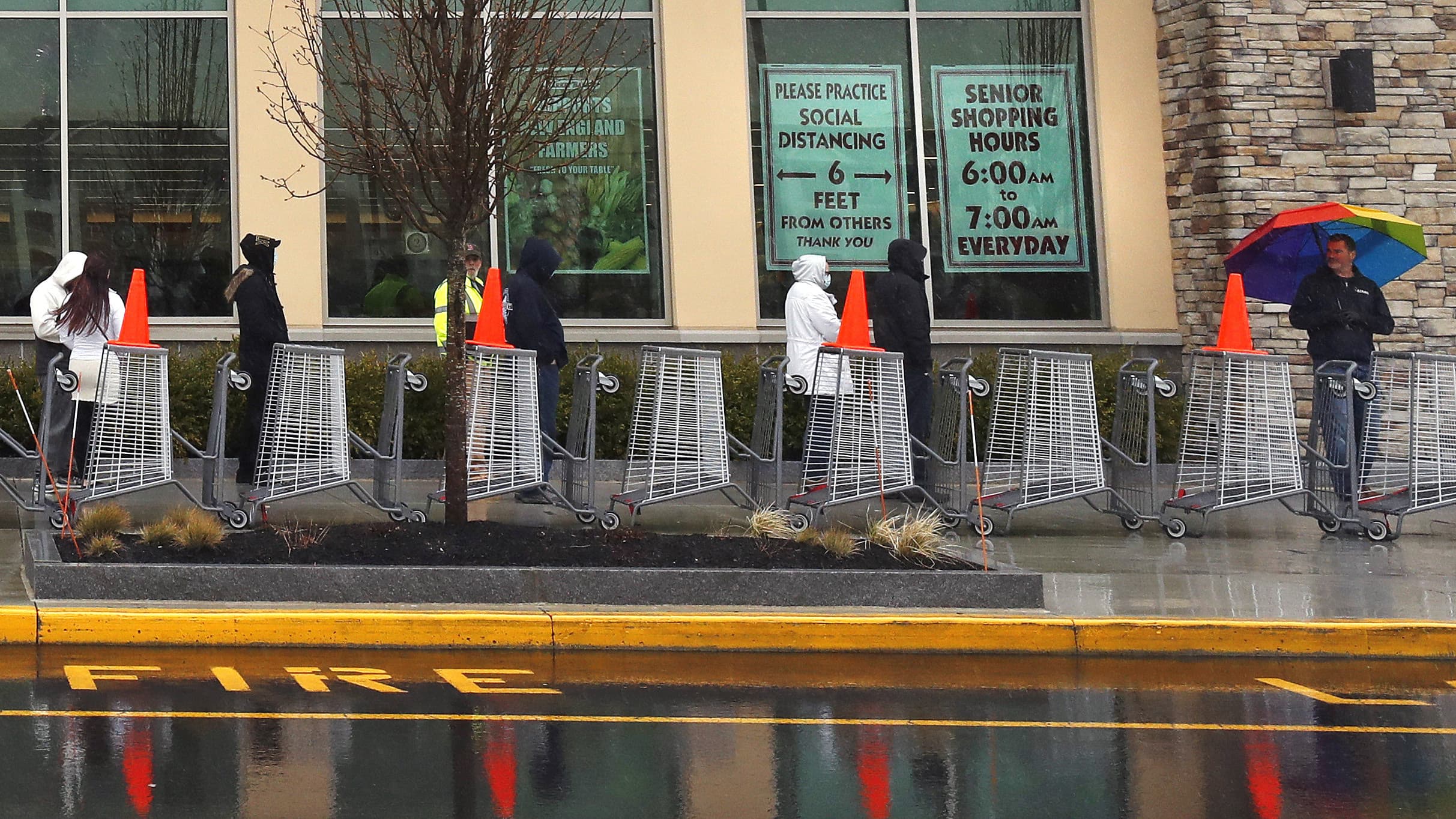 Window signs remind shoppers to keep their distance while waiting in for their turn to shop, after customer capacity was limited due to the coronavirus outbreak, at the Market Basket store in Salem, N.H. (Charles Krupa/AP)