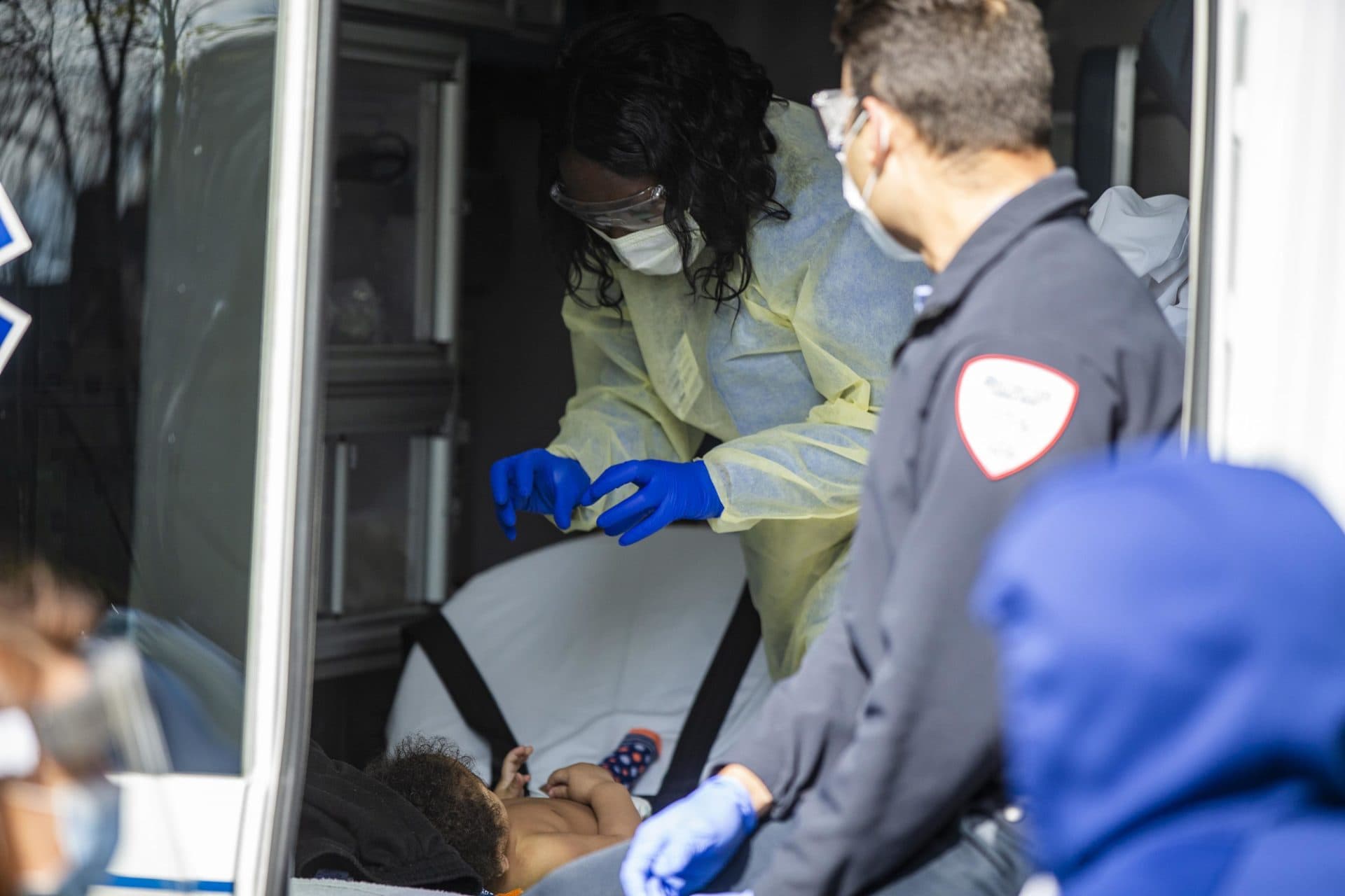 BMC nurse Priscilla Stout playfully interacts with a baby during an exam in the back of an ambulance being used by Boston Medical Center to deliver routine care likely interrupted by the coronavirus to children. (Jesse Costa/WBUR)