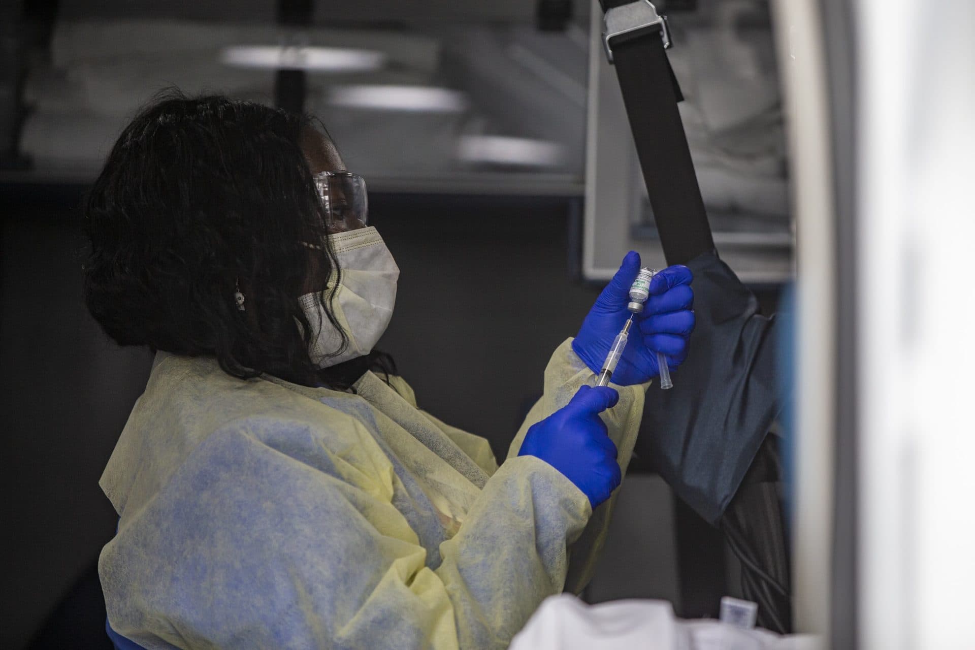 BMC nurse Priscilla Stout prepares an inoculation in the back of the ambulance. (Jesse Costa/WBUR)