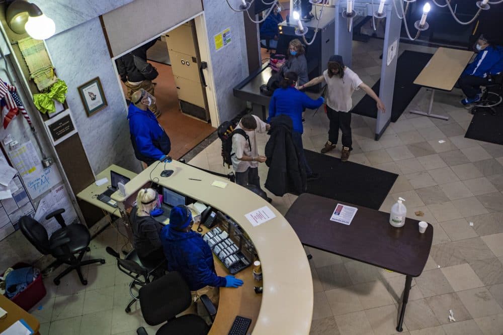 A guest is checked with a metal detector upon entering the building of St. Francis House in Boston. (Jesse Costa/WBUR)