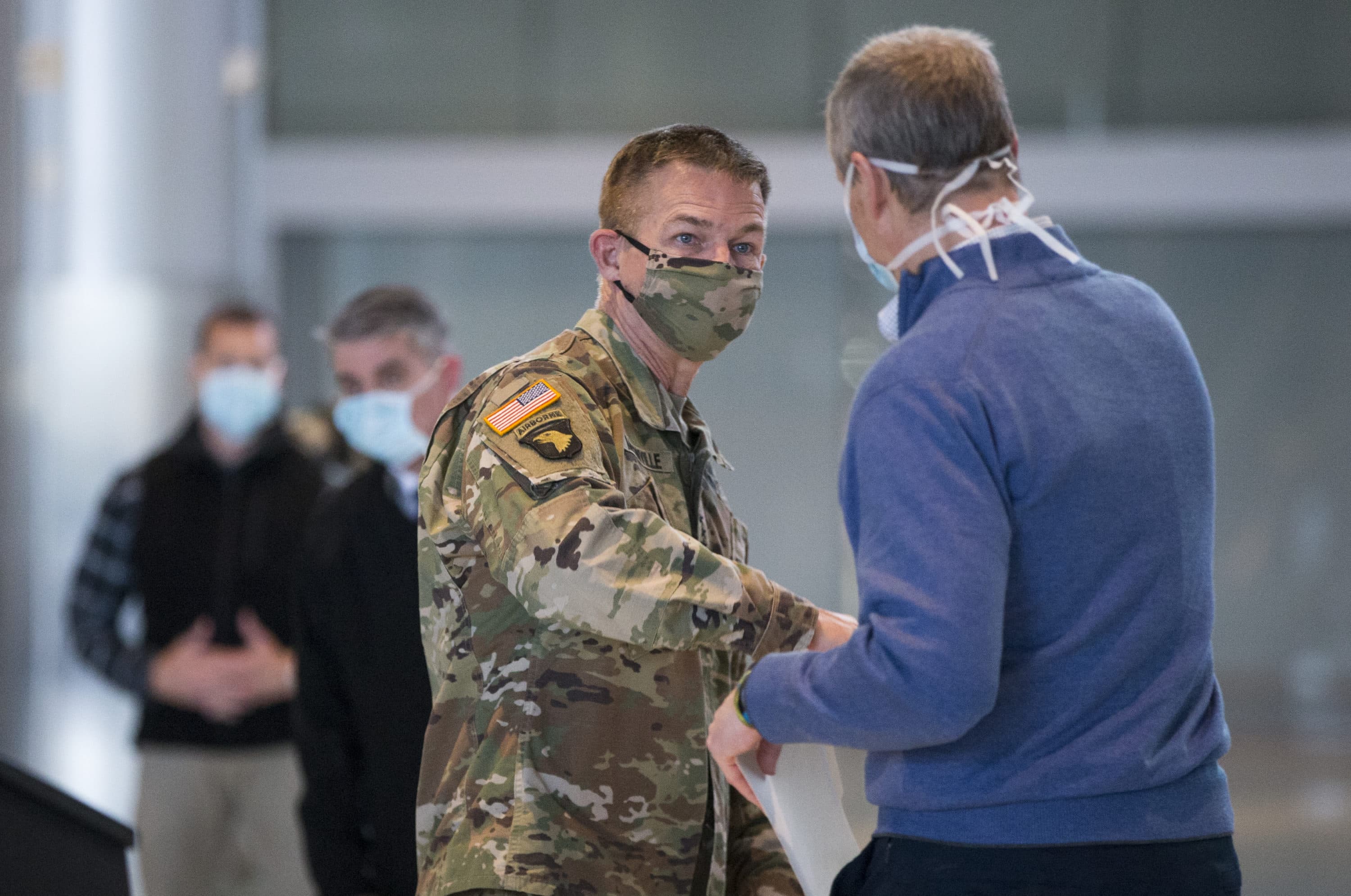 Gov. Charlie Baker and U.S. Army Chief of Staff General James C. McConville elbow "bump" after their press conference in the Boston Convention & Exhibition Center on April 18, 2020. (Blake Nissen/The Boston Globe)